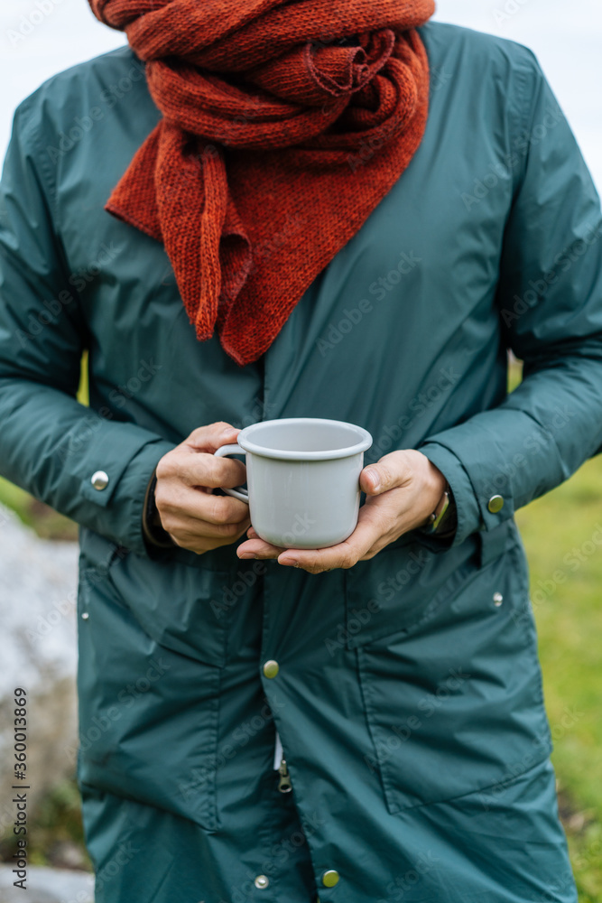 Crop person with hot beverage in nature Crop person with hot beverage in nature