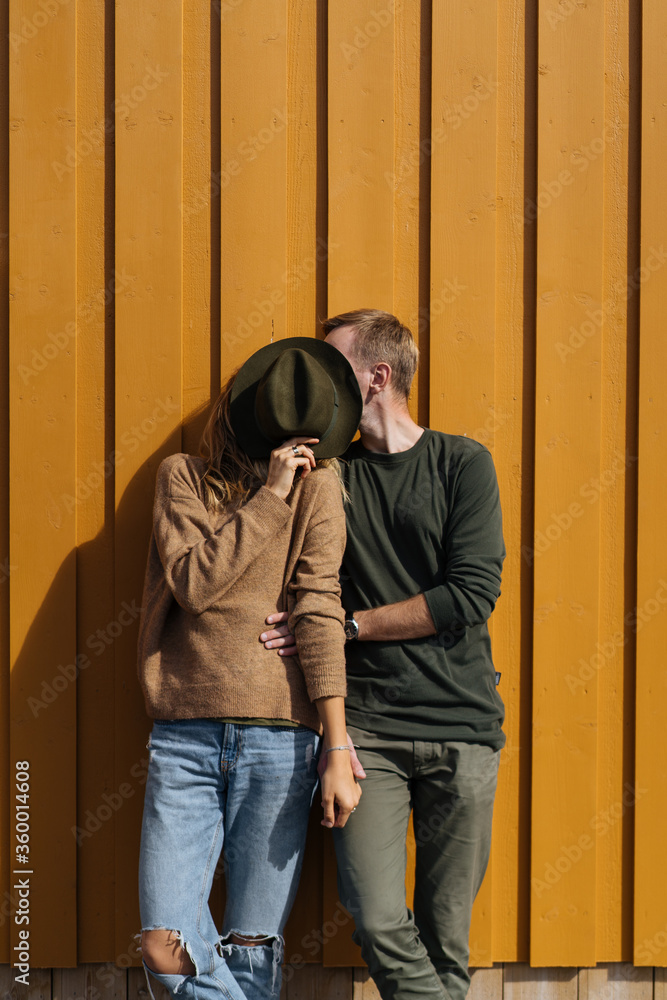 Couple kissing covering faces with hat Couple kissing covering faces with hat