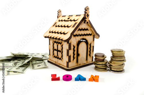 Model of a wooden house, money and the word "loan" on white. real estate, mortgage and investment concept.