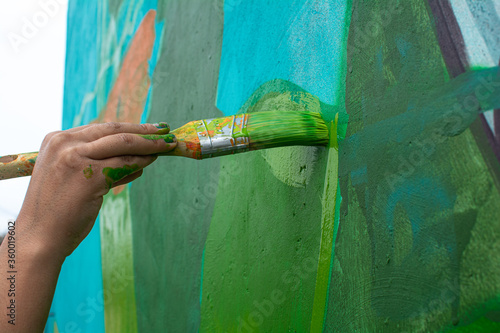 Mano pintando muro de color verde photo