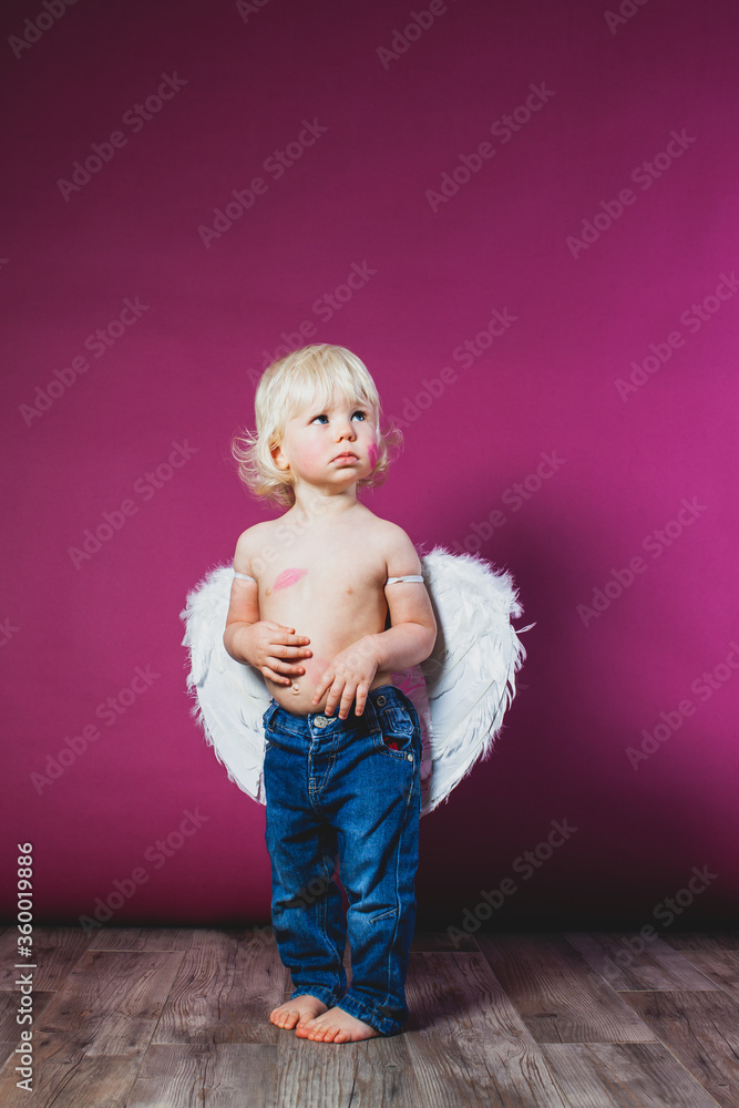 Fototapeta premium Toddler boy in jeans and angel wings