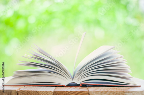 open book on the table in the nature background with bokeh lights
