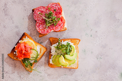 Close-up three sandwiches with various contains on light murble surface photo