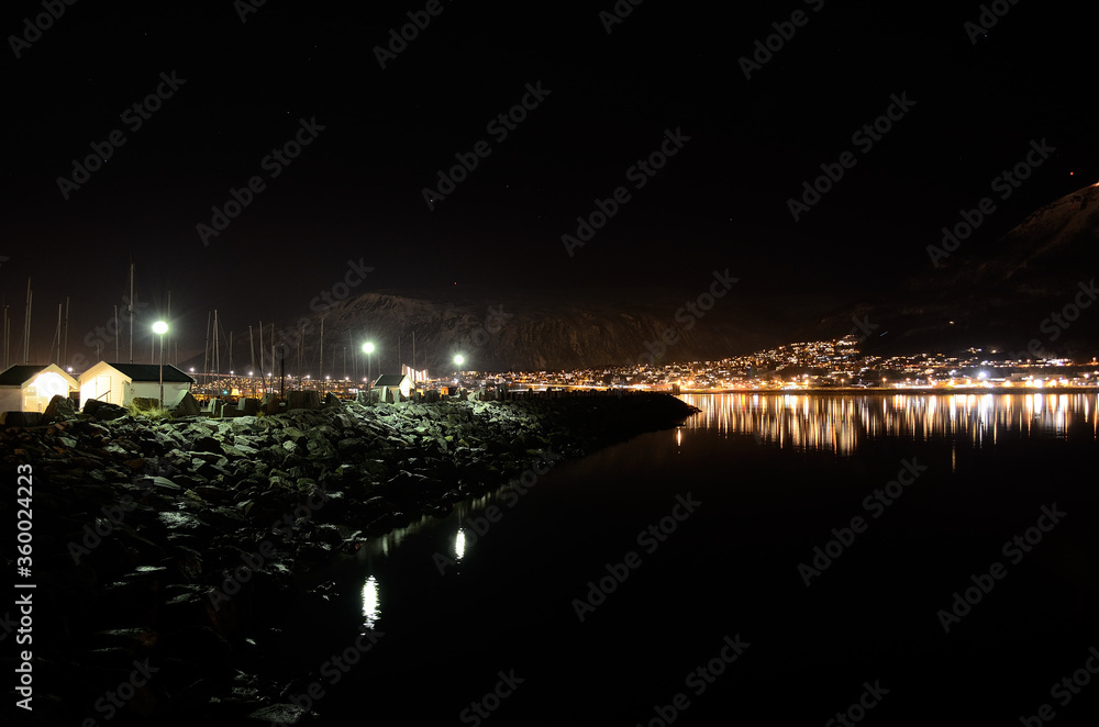 city lights at night with reflection on sea surface