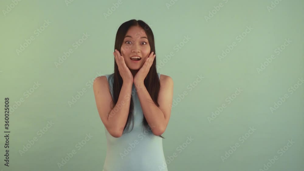 Shock. Portrait midle shoot. Very surprised Asian girl. Girl covers her mouth with hand 4K Shock. Portrait midle shoot. Very surprised Asian girl. Girl covers her mouth with hand 4K