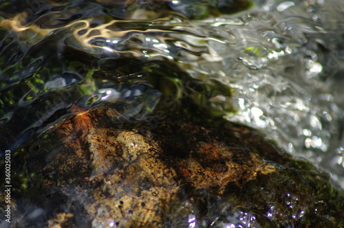 Crystal splashes of water  playful foam in the streams of the river. Stones under the streams of a swift  mountain river...