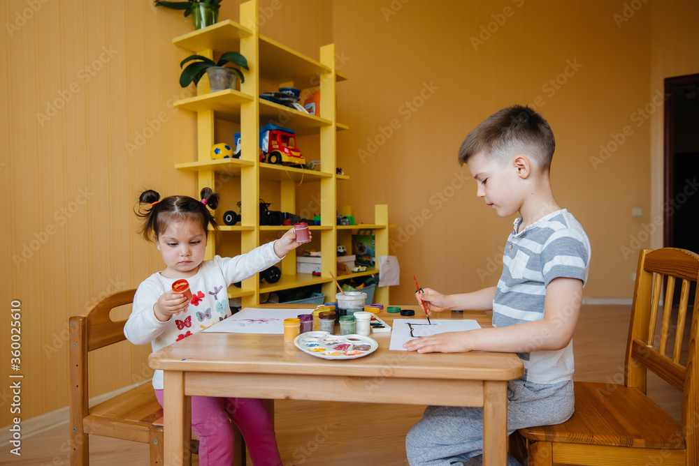 A boy and a girl play together and paint. Recreation and entertainment. Stay at home A boy and a girl play together and paint. Recreation and entertainment. Stay at home