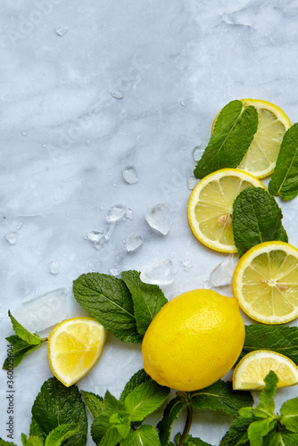 Summer background composition with lemon slices, leaves mint and ice cubes. Minimal lemonade drink concept. Top view