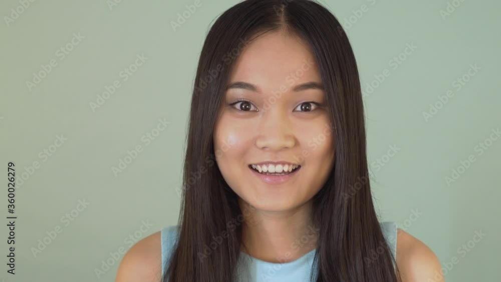 Portrait Close-up. Very surprised Asian girl. Girl covers her mouth with hand 4K Portrait Close-up. Very surprised Asian girl. Girl covers her mouth with hand 4K