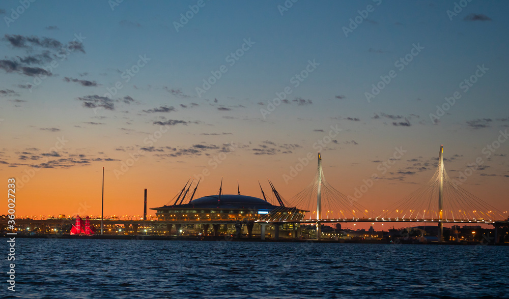 A ship with red sails at sunset on the background of a beautiful city and a skyscraper A ship with red sails at sunset on the background of a beautiful city and a skyscraper