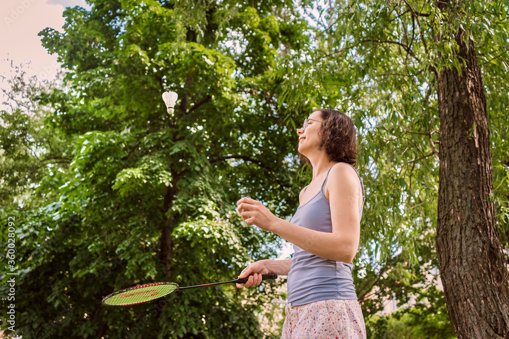 A girl alone playing badminton in the Park. Sports and games in the fresh air with the racket. A girl alone playing badminton in the Park. Sports and games in the fresh air with the racket.