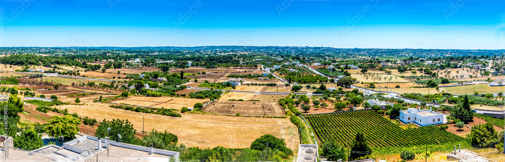 A view of the road and fields between the settlements of Locorontondo and Martina Franca, Puglia, Italy in the summertime