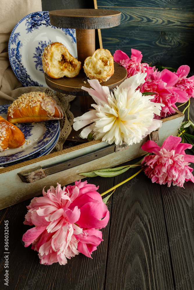 Breakfast with croissants, leaves, flowers composition with retro plates on wooden background Breakfast with croissants, leaves, flowers composition with retro plates on wooden background