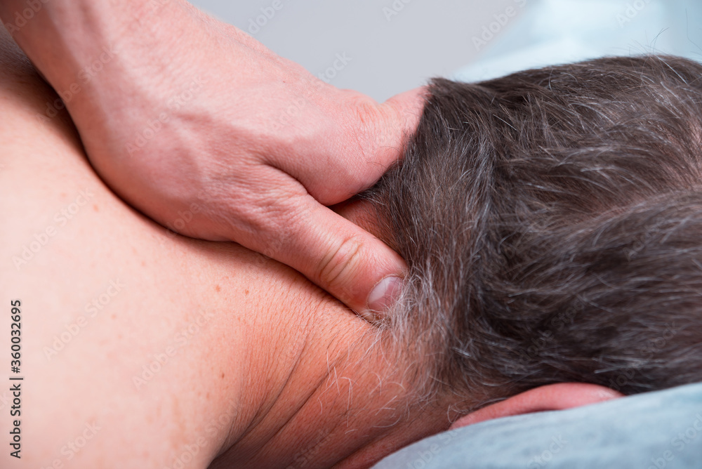 Physical therapist is making some deep massage on a mans neck. Physical therapist is making some deep massage on a mans neck.