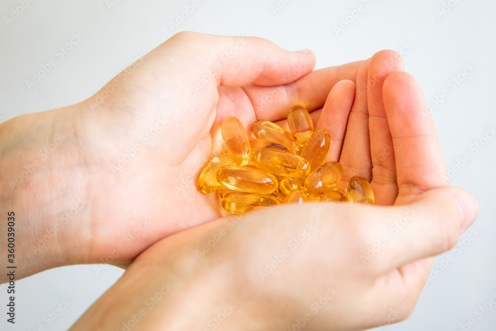 Yellow capsules of vitamin omega 3 in your hand. Biologically active additive. Fish oil in tablets. Medical support and treatment. Yellow capsules of vitamin omega 3 in your hand. Biologically active additive. Fish oil in tablets. Medical support and treatment.