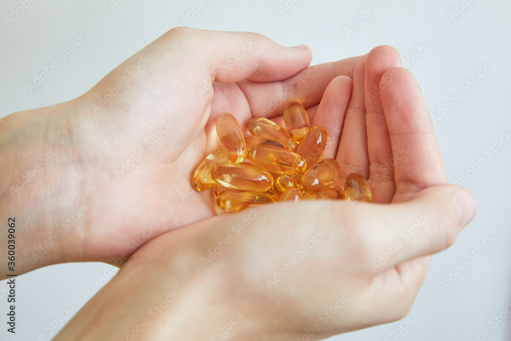 Yellow capsules of vitamin omega 3 in your hand. Biologically active additive. Fish oil in tablets. Medical support and treatment. Yellow capsules of vitamin omega 3 in your hand. Biologically active additive. Fish oil in tablets. Medical support and treatment.