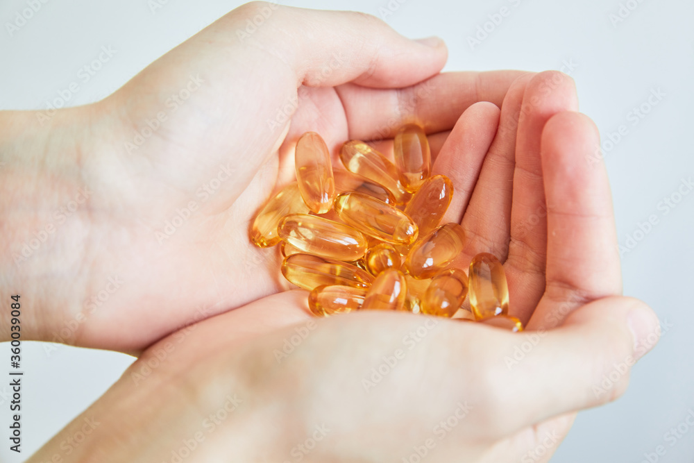 Yellow capsules of vitamin omega 3 in your hand. Biologically active additive. Fish oil in tablets. Medical support and treatment. Yellow capsules of vitamin omega 3 in your hand. Biologically active additive. Fish oil in tablets. Medical support and treatment.