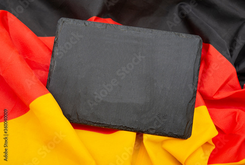 Emptry slate sign on german flag background with copy space. photo