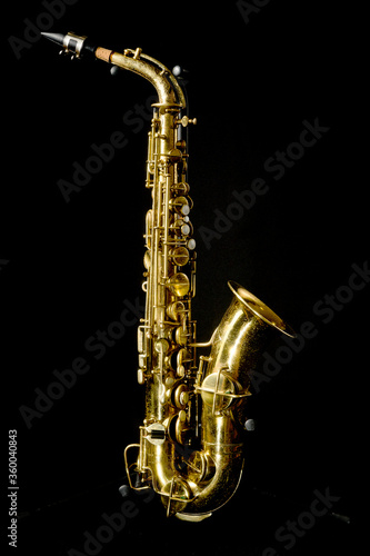a complete view of a gold saxophone with mechanisms and buttons, an elegant and complex but beautiful wind instrument
