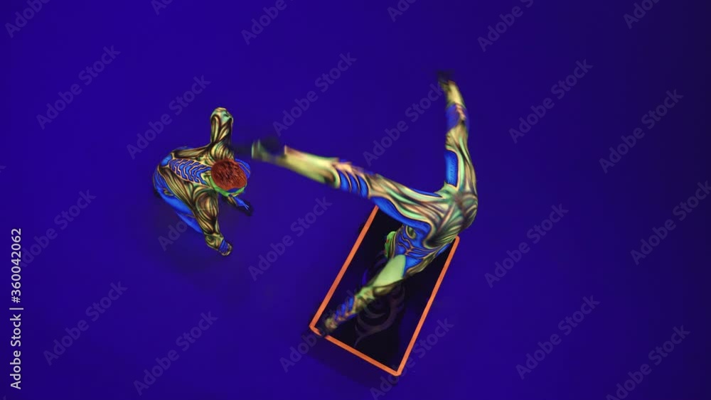 Acrobatic twins in neon costumes to perform a stand on the hands and ...