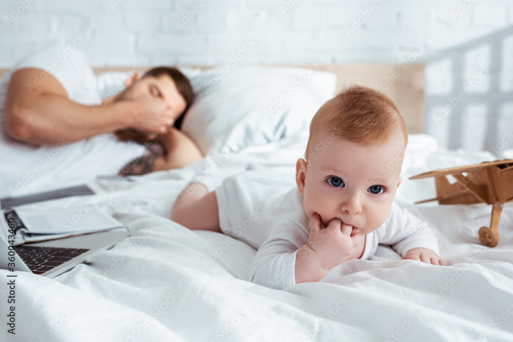 selective focus of cute infant crawling on bed neat tired father selective focus of cute infant crawling on bed neat tired father