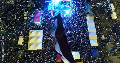 Beirut, Lebanon 2019: night fix drone shot in martyrs' square, with Lebanese flag in foreground and hundreds of protesters around a stage revolting against government during the Lebanese revolution photo