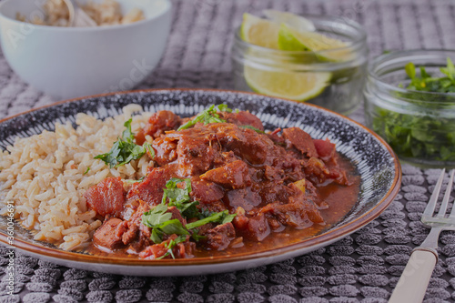 Chicken curry and rice, with some lime wedges in the background.