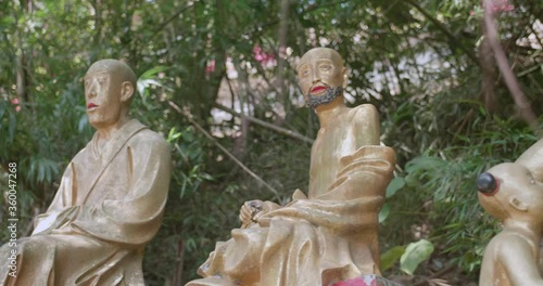 Dolly shot of buddha statues in a row. Ten Thousand Buddhas Monastery, Sha Tin, Hong Kong. Peaceful golden religious figures. High dynamic range footage. photo