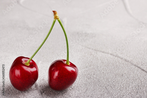 couple sweet cherry closeup on concrete background. ripe berries sweet cherry