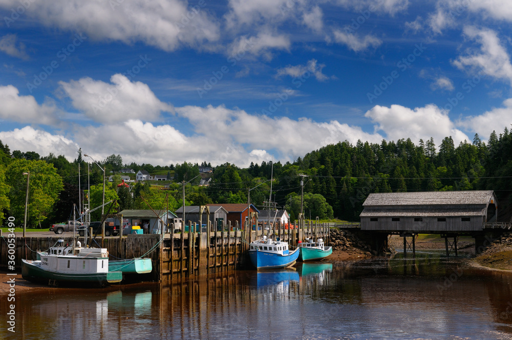 Covered bridge and wharf with boats at low tide in St Martins New Brunswick