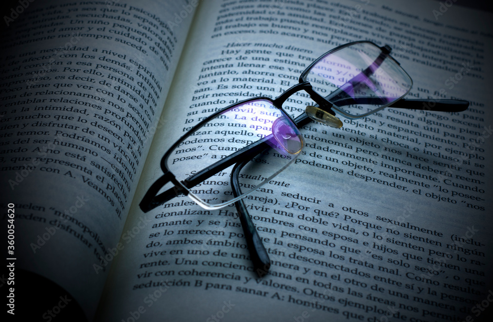 A open book in spanish with glasses. A open book in spanish with glasses.