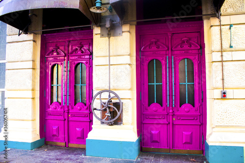 vintage pink door on yellow wall, building exterior