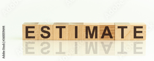 Word ESTIMATE is made of wooden building blocks lying on the table and on a light white background. Concept