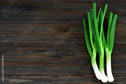 Spring onions on wooden background with copy space