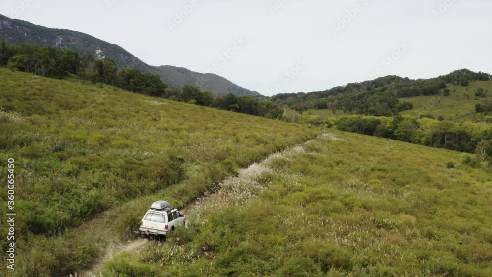 Aerial view of jeep driving offroad along Chandalaz mountain ridge, Primorye, Russia Aerial view of jeep driving offroad along Chandalaz mountain ridge, Primorye, Russia