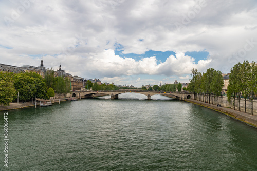 View of medieval palace Conciergerie, Seine river with barge and Neuf bridge in Paris, France