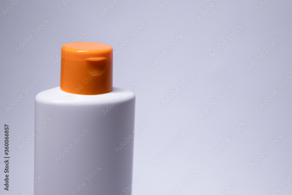 a yellow shampoo bottle with yellow neck and no label. body care and beauty concept. Copy space. High quality photo a yellow shampoo bottle with yellow neck and no label. body care and beauty concept. Copy space. High quality photo