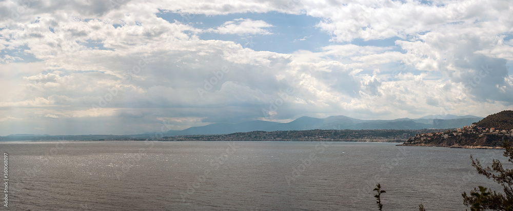Panoramic View of West Part of Nice City, France from Edge of Cape of Cap Ferrat District - Summer Landscape with Clouds Pouring Short Rain into Sea and Mountains on Background