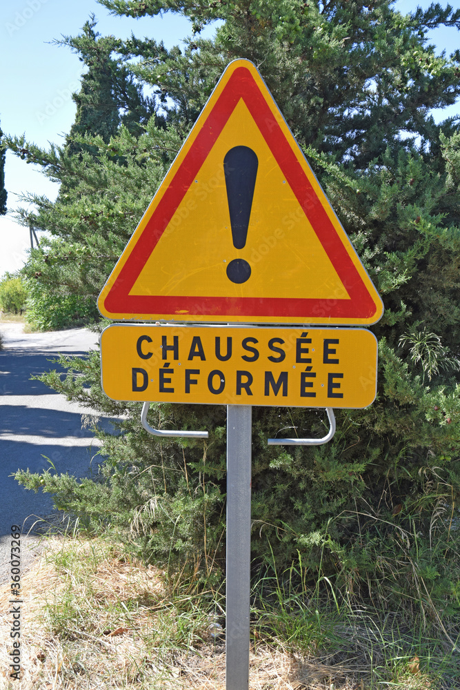 Panneau : provisoire, jaune, chaussée déformée. Panneau : provisoire, jaune, chaussée déformée.