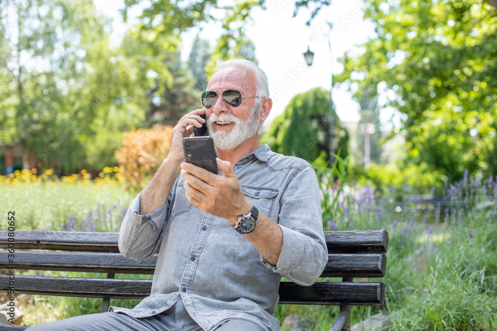 Old man compare two smartphones Old man compare two smartphones