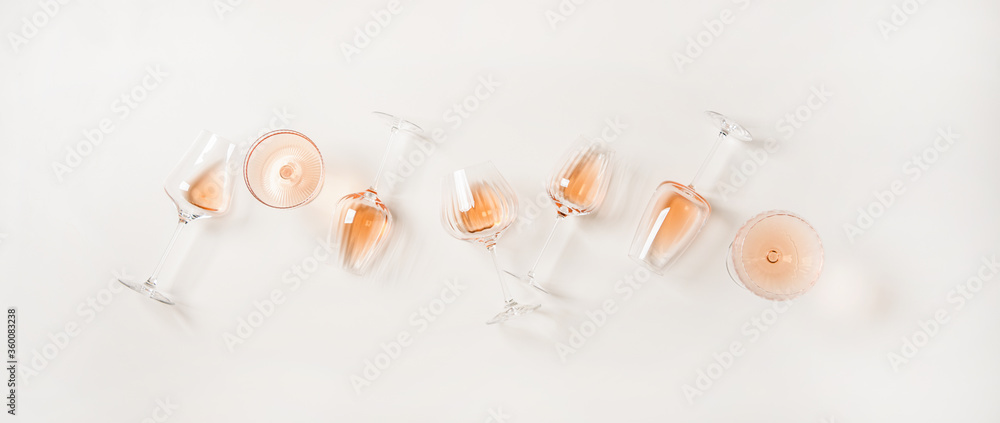 Rose wine variety layout. Flat-lay of rose wine in various glasses over plain white background, top view. Summer drink for party, wine shop or wine tasting concept - obrazy, fototapety, plakaty 