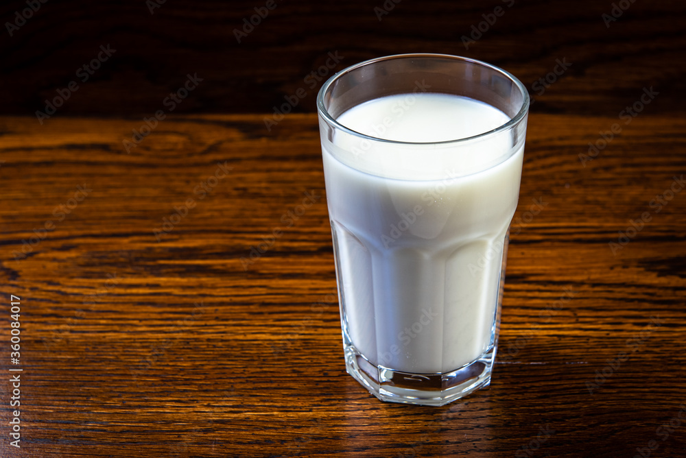 glass of milk on old wooden table dark background glass of milk on old wooden table dark background