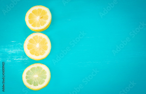 Turquoise background with three lemon slices