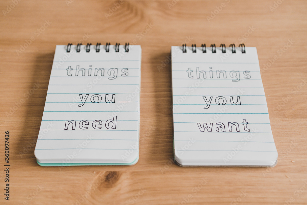 notepads with titles Things you need vs things you want side by side on desk ready for meditation notepads with titles Things you need vs things you want side by side on desk ready for meditation