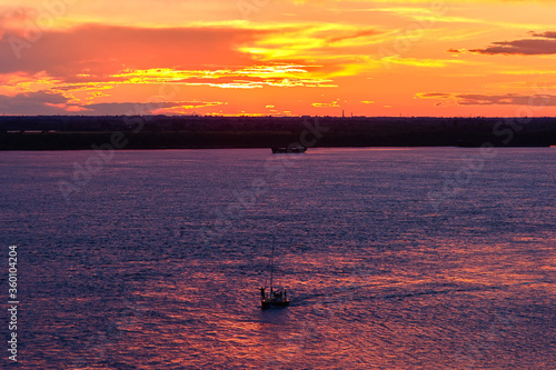 Silhouette of man in a boat on a river at sunset © Алексей Сыркин