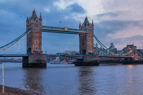 View of the London city skyline at sunset on a cloudy day with Tower Bridge on Thames river in England, United Kingdom