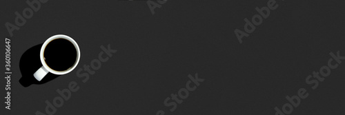 White cup with a coffee on a black background. Top view, flat lay. Banner