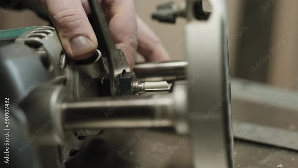 Close-up of a carpenter changing the router bit on a router power tool. Close-up of a carpenter changing the router bit on a router power tool.
