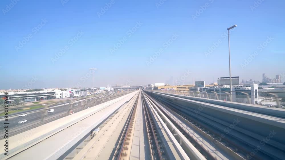 Dubai Metro Train Travelling On The City With Cars In Sheikh Zayed Road On A Bright Weather In Dubai, UAE. - wide shot Dubai Metro Train Travelling On The City With Cars In Sheikh Zayed Road On A Bright Weather In Dubai, UAE. - wide shot