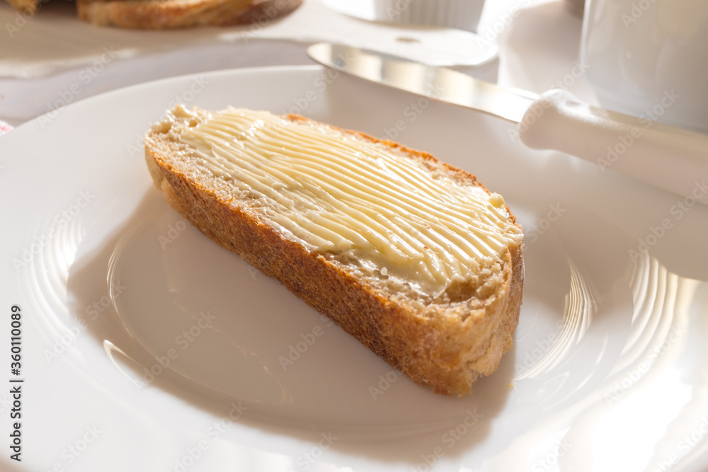 Mesa com Café da Manha: Pão Integral com manteiga, chícara de café, bule com café, toalha vermelha xadrez, pão integral fatiado sobre tábua branca, manteiga no ramequim, pão com manteiga Ponto de vist Mesa com Café da Manha: Pão Integral com manteiga, chícara de café, bule com café, toalha vermelha xadrez, pão integral fatiado sobre tábua branca, manteiga no ramequim, pão com manteiga Ponto de vist